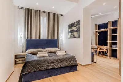 a bedroom with a large bed and a desk at Coliseum sweet guest house in Rome