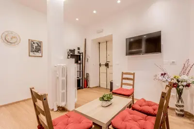 a living room with a table and chairs and a television at Coliseum sweet guest house in Rome