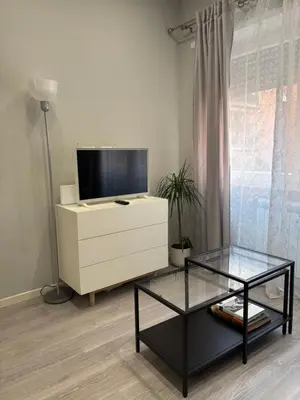 a living room with a tv and a dresser at Le Quattro Stagioni Vatican City in Rome