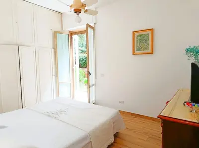 a white bedroom with a bed and a window at [Rome] House with garden near the Olympic Stadium in Rome
