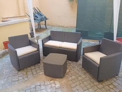 three wicker chairs and a bench on a patio at Domus Fanti in Rome
