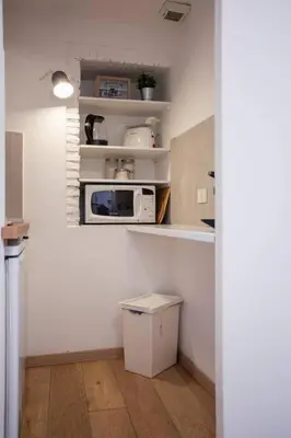 a small kitchen with a microwave and a refrigerator at MyRentalInn - Rome - Trastevere Arch Suite in Rome