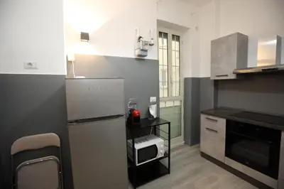 a small kitchen with a refrigerator and a sink at Viale Trastevere Apartment in Rome