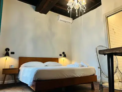 a bedroom with a bed and a chandelier at Cenci Guest House in Rome