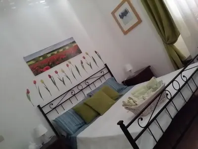 a bedroom with a white bed with green pillows at Holiday Home Il Sogno A San Pietro in Rome
