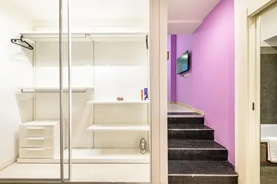 a walk in closet with purple walls and stairs at Deluxe Apartments Pantheon in Rome