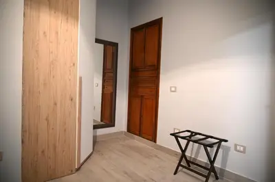 an empty room with a wooden door and a stool at Mirabilia Suites Colosseum in Rome
