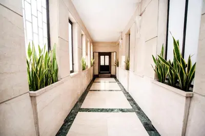 an empty corridor with plants in a building at Mirabilia Suites Colosseum in Rome