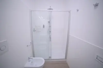 a white bathroom with a shower and a toilet at Toscani 24 in Rome