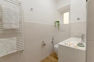 a white bathroom with a toilet and a sink at Casa Coppedè in Rome