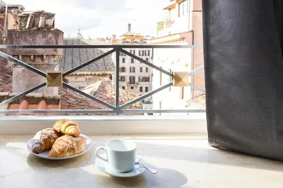 a plate of croissants and a cup of coffee next to a window at Pantheonview - Luxury Suites in Rome