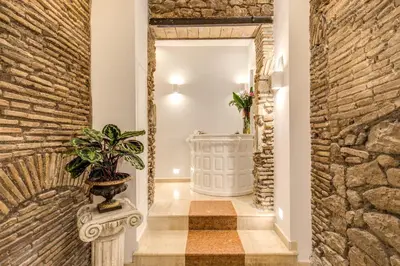 a hallway with a stone wall and a potted plant at Pantheonview - Luxury Suites in Rome