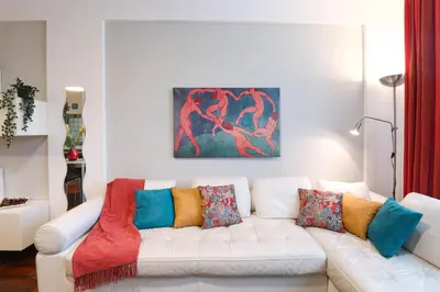 a living room with a white couch with colorful pillows at Margot - Quiet and Elegant with Free Parking in Rome