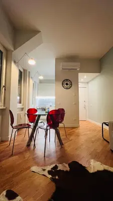 a living room with a table and chairs and a clock at Archimede 35 One step away from the center in Rome