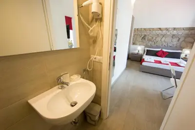 a bathroom with a sink and a bed in a room at The Great Beauty in Rome