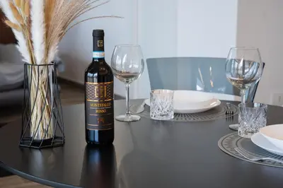 a bottle of wine sitting on a table with glasses at Attico Esclusivo Trastevere with Rooftop Terrace in Rome