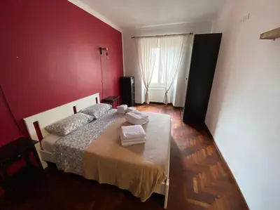a bedroom with a bed in a red wall at Casa Di Lella, a due passi dal Vaticano in Rome