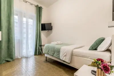 a bedroom with a bed and a window with green curtains at La Casa di Umberto in Rome