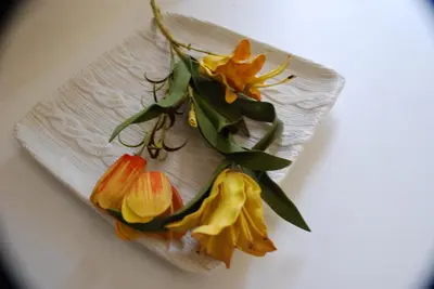 a bunch of flowers on a plate on a table at Costantino Primo Holiday - Roma St.Pietro in Rome