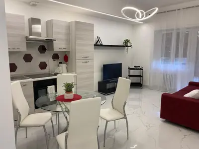 a living room with a glass table and white chairs at Tiburtina Flats in Rome