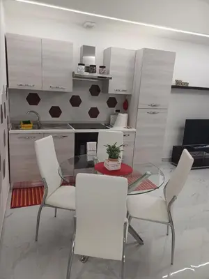 a dining room with a glass table and white chairs at Tiburtina Flats in Rome