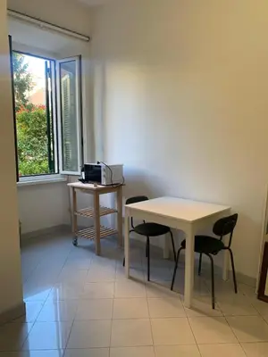 a table and chairs in a room with a window at Appartamento degli Eroi in Rome