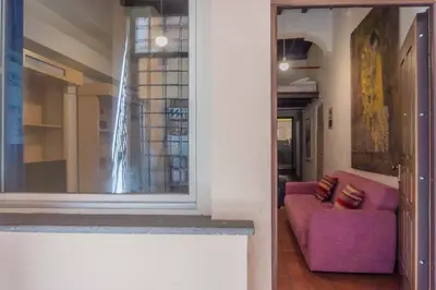 a living room with a purple couch and a window at Domus Reginella, nella zona più richiesta di Roma in Rome