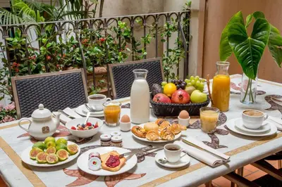 a table with a breakfast of fruit and juice at Sant'Andrea - Opulence Apartment in Rome