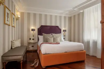 a bedroom with a large bed with a purple headboard at Sant'Andrea - Opulence Apartment in Rome