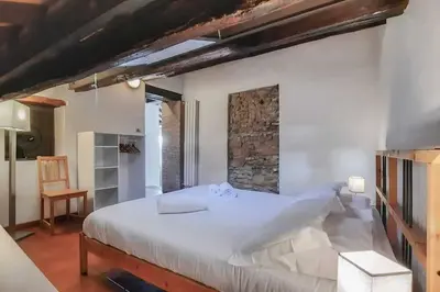 a bedroom with a large white bed and a chair at Domus Tempio Deluxe, Roma Centro in Rome