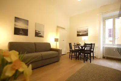 a living room with a couch and a table with chairs at San Lorenzo Holiday House in Rome