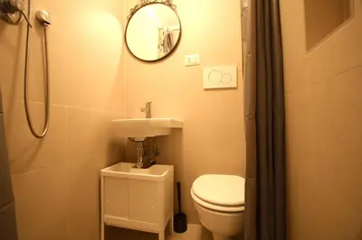 a bathroom with a toilet and a sink and a mirror at San Lorenzo Holiday House in Rome
