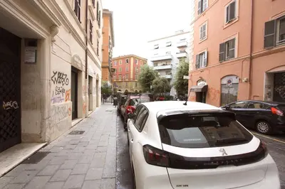 a white car parked on the side of a street at San Lorenzo Holiday House in Rome