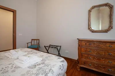 a bedroom with a bed with a dresser and a mirror at Jubilee apartment Vatican Museums in Rome