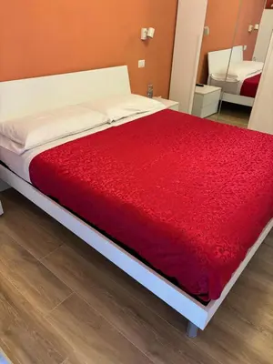 a bed with a red blanket on top of it at Suite and room in Rome