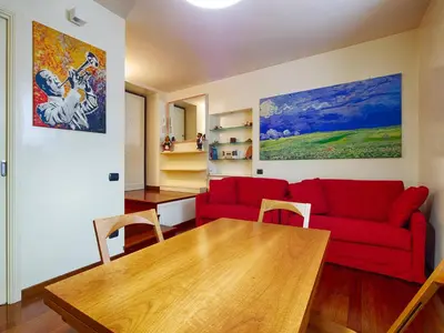 a living room with a red couch and a wooden table at Sweet Home Colosseo in Rome