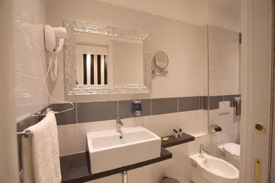 a bathroom with a sink and a toilet and a mirror at Guesthouse Interno 7 Luxury Rooms in Rome