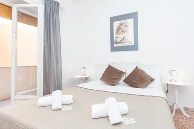 a white bedroom with a bed with two pillows at via Madonna del Riposo in Rome