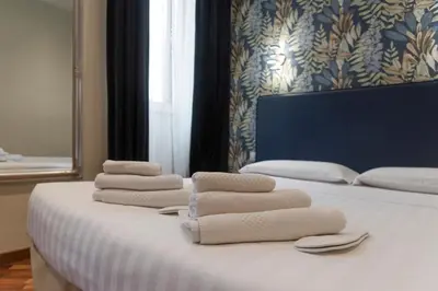 a bed with white towels on top of it at La Grande Bellezza Guest House Rome in Rome