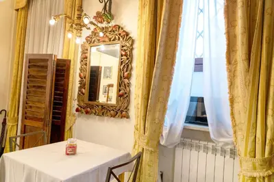 a table in a room with a mirror and curtains at Colosseum Charming Loft - Santa Maria in Carinis in Rome