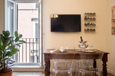 a room with a table with chairs and a television on the wall at AV Domus Propaganda in Rome