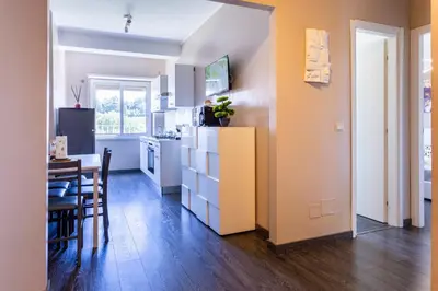 a kitchen and dining room with a table and a refrigerator at Cipro Vatican House in Rome