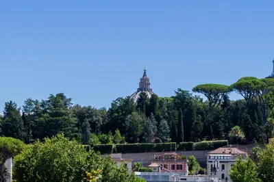 a building on top of a hill with trees at Cipro Vatican House in Rome