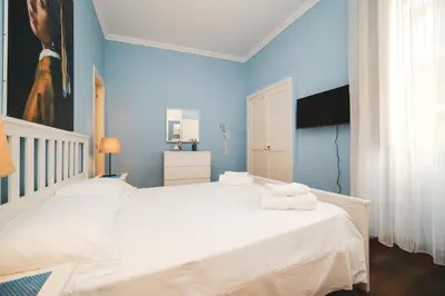 a bedroom with a large white bed and blue walls at Pettinari by BuddyRent in Rome