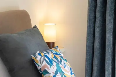a lamp sitting next to a couch with a pillow at Appartamento San Pietro-Vaticano in Rome