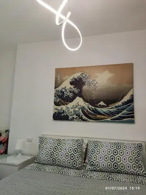 a painting of a wave hanging on a wall at ROMAN'S HOUSE in Rome