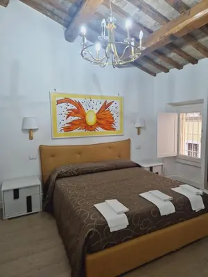 a bedroom with a large bed and a chandelier at Borgo Pio 182 Vatican Suite in Rome