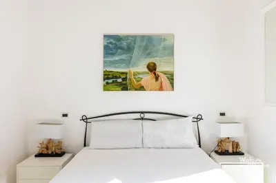 a bedroom with a bed with a painting on the wall at Maison Borghetto - Vatican House in Rome