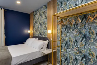 a bedroom with a bed with a blue and gold wall at NAIF Suites in Rome