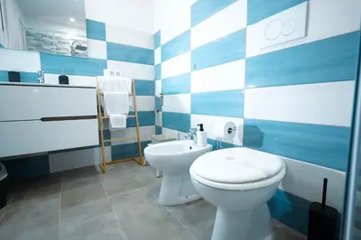 a blue and white bathroom with a toilet and a sink at Salotto Tiburtino in Rome